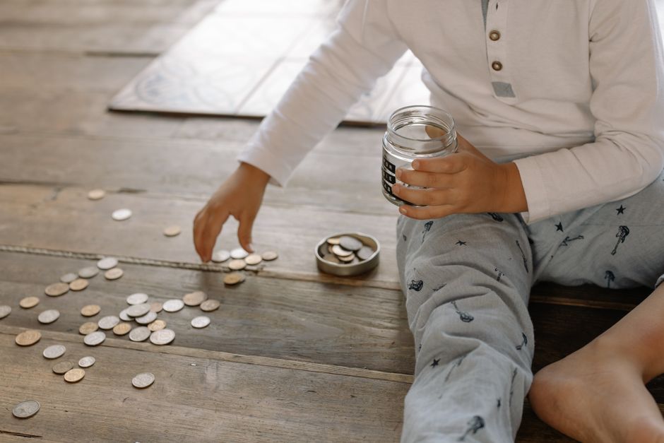子どもが硬貨を瓶に集めている様子
