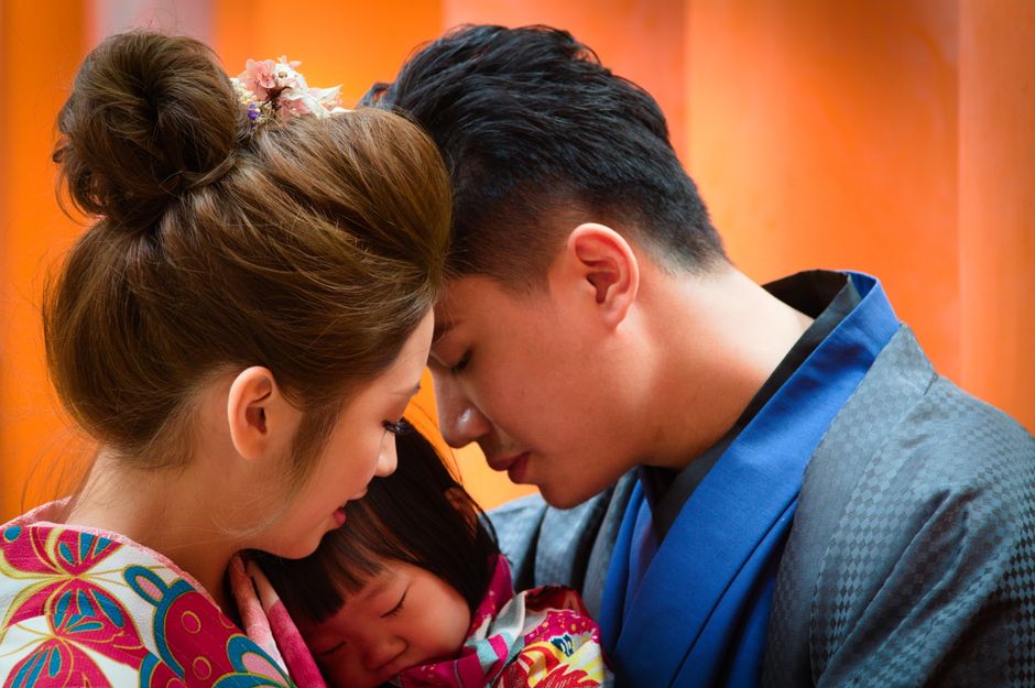 着物姿の両親と子供が額を寄せ合う家族写真